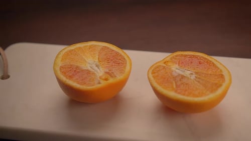 Frisch geschnittene Orangenhälften, wunderschön angeordnet auf einem Holztisch inmitten der Natur