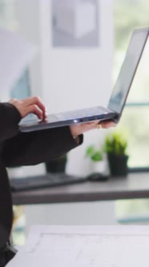 Vertical Video Architect Takes Notes on Laptop for Development Plan