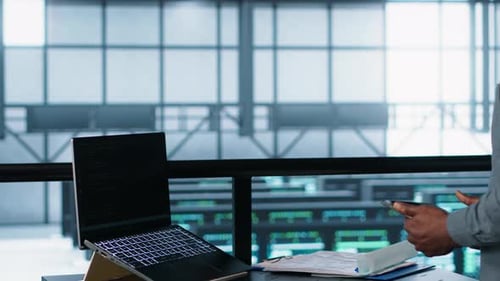 Technician in Data Center with Laptop and Tablet Integrating AI Technology