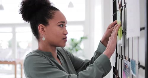 Portrait of African American businesswoman ne,t to noticeboard