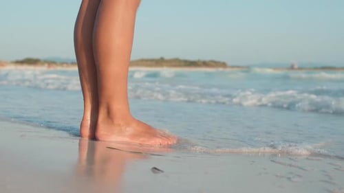 Closeup Wet Woman Legs Standing on Seashore in Summer Day. Sea Waves