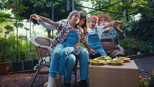 Family enjoying a meal together in their vegetable garden