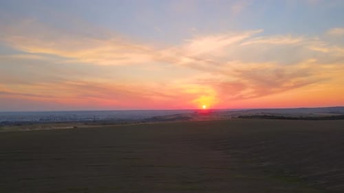 Tractor Spraying Fertilizers with Insecticide Herbicide Chemicals on Agricultural Field at Sunset