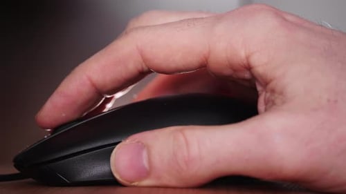 Close Up A Person's Hand Scrolling And Left-clicking On A Mouse. static shot