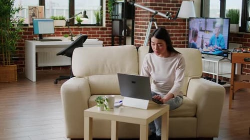 Focused Woman Working on Laptop in Cozy Home