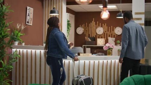 Hotel Guests Checking in at Reception Desk