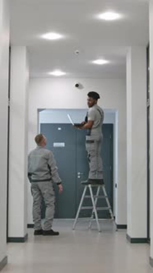 Two Men Working on Security Camera Installation