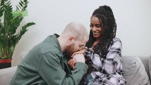 Loving Couple Sitting Together on Sofa Indoors