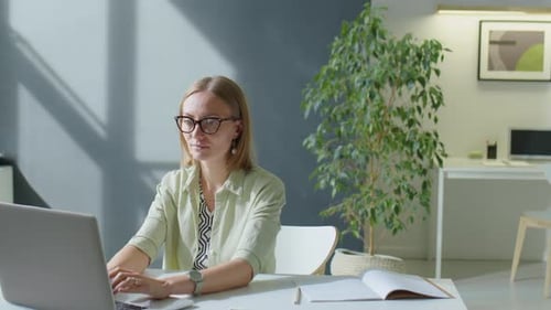 Portrait of Smiling Businesswoman Working on Laptop in Office