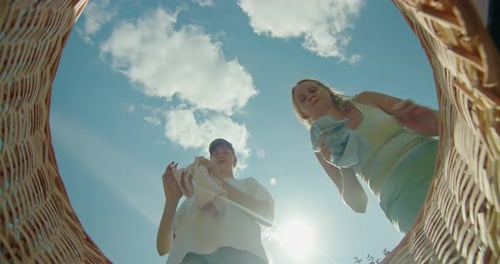 A Woman and Her Teenage Daughter Fold Clothes Into a Basket Enjoying Quality Time Together Sharing