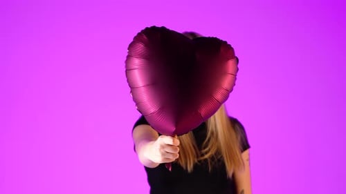 Girl With Heart Balloon Points Forward