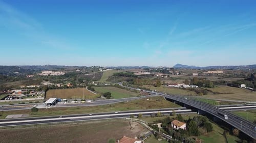 Drone Footage of Highway Surrounded By Agriculture Fields and Forest During Spring Morning