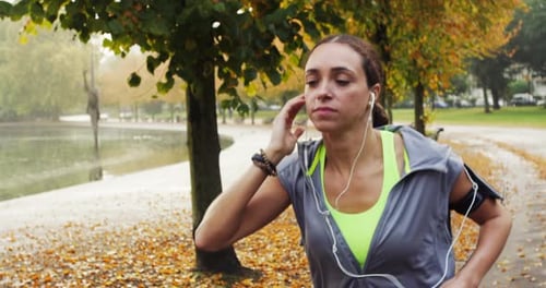 Woman Jogging in Park on Autumn Day