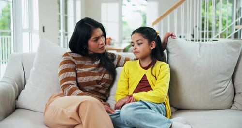 Concerned Mother Comforting Child on Sofa at Home