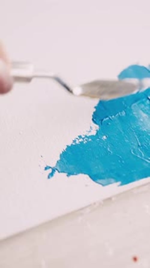 Blue Paint Being Applied to a Canvas