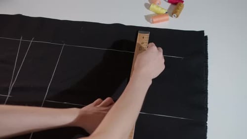 Woman Marking Fabric in Studio