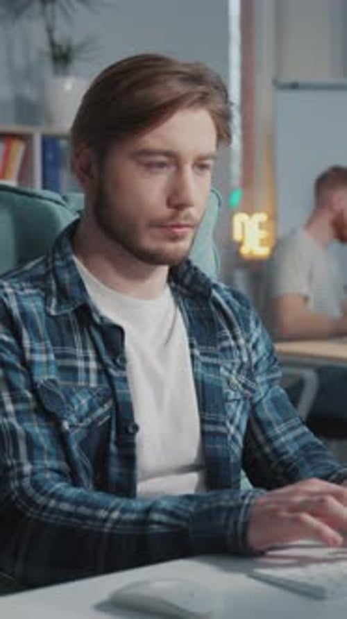 Bearded IT Administrator Programming Code Typing Computer Keyboard Desktop Sitting in Coworking