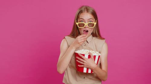 Young Woman Eating Popcorn Wearing 3D Glasses