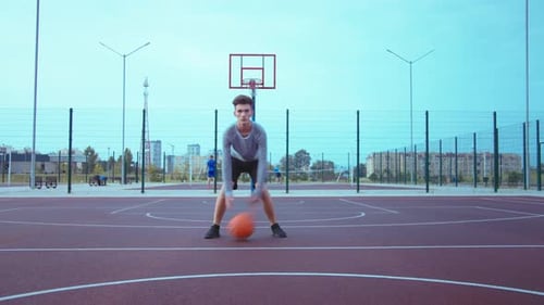 Teen Dribbling Basketball on Outdoor Urban Court