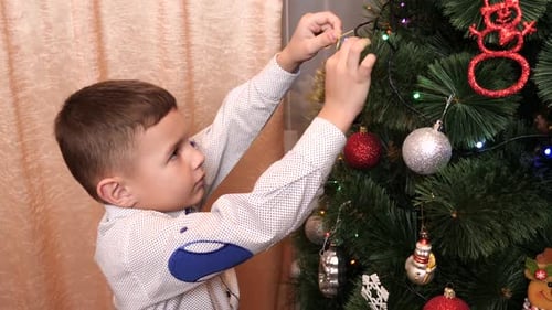 Boy Decorating Christmas Tree with Ornaments