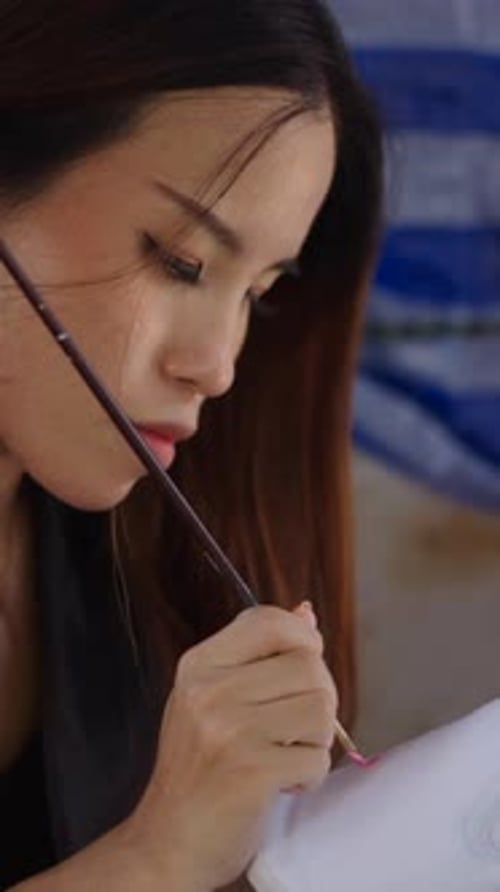 Woman Painting a Design on White Shoe