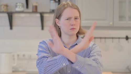 Young Woman Gesturing No with Arms Crossed