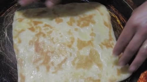 Special Moroccan pancakes called MSEMEN during the preparation in iron fryer