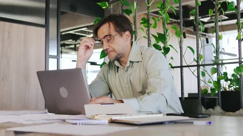 Man Working on Laptop in Modern Office