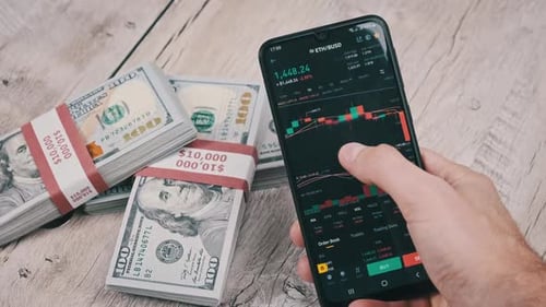 Trader Analyzes Ethereum Cryptocurrency Prices on Smartphone Above Dollars