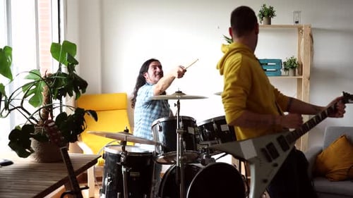Drummer and Guitarist Play Energetically in Living Room