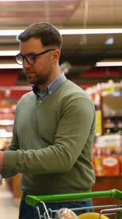 Man Selecting Bottled Water at the Supermarket