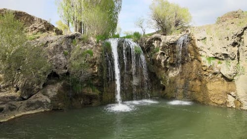 Waterfall Flowing Into a Pond on a Sunny Day