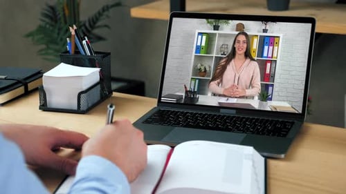 Man Attends Video Conference and Takes Notes