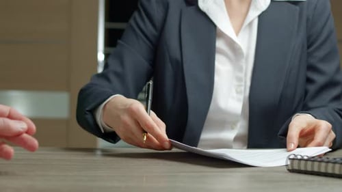 Unterzeichnung eines Vertrags zwischen zwei am Tisch sitzenden Partnern. Unterzeichnung eines Dokuments mit dem Kunden.