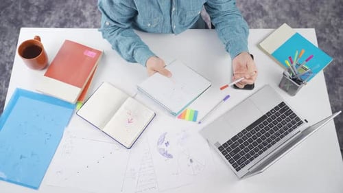 Working at Desk with Laptop and Notebook