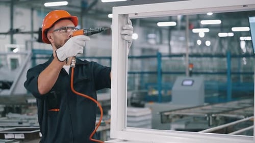 Mit einem Schraubenzieher. Der Mensch arbeitet in der modernen Fabrik.