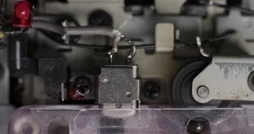 Close-Up Of Playhead And Pinch Roller Operating Inside Microcassette Recorder With Pulsing LIght Eff