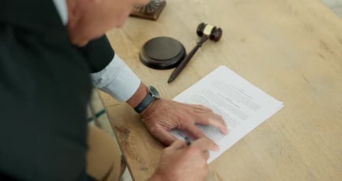 Man Signing Legal Document with Gavel