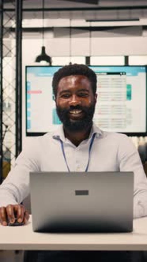 Man Works On Computer at Desk in Office
