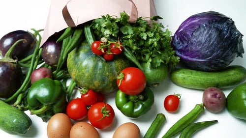 Verduras y huevos que se derraman de una bolsa de papel, una variedad de verduras y huevos frescos