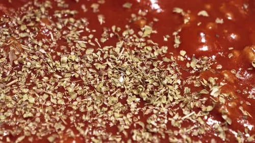 Close-up View, Stirring in the Bolognese Sauce with a Wooden Pot Spoon, Adding Oregano to the Sauce