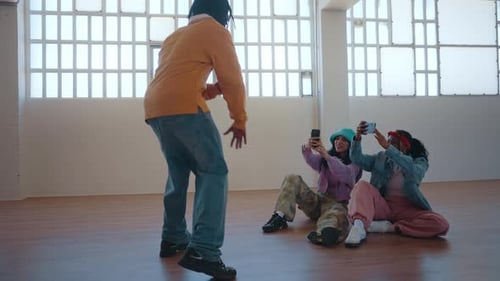 Three People Recording Young Man Dancing