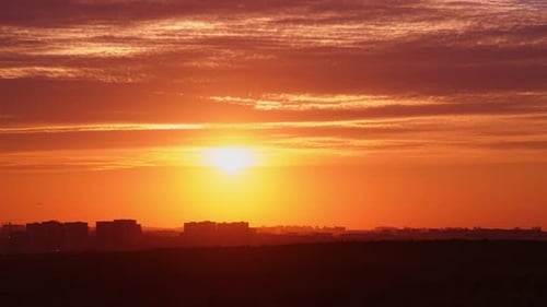 The setting sun paints the evening sky with a fiery red sunset.