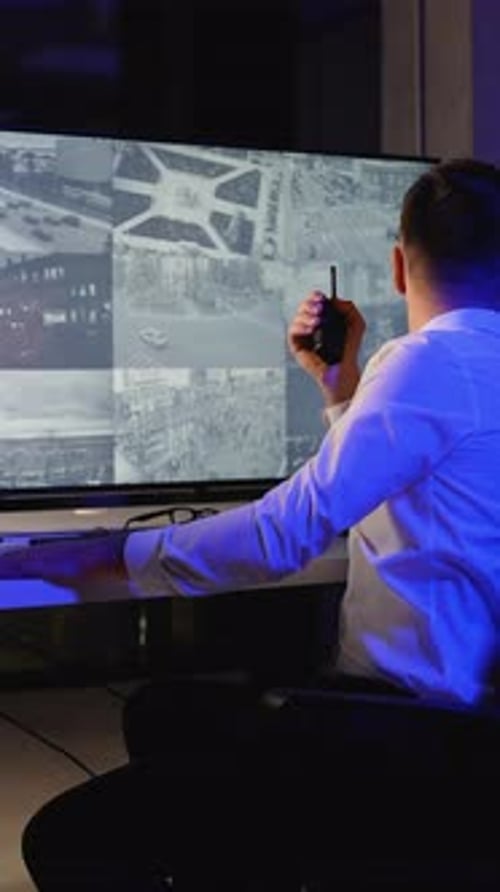 Security Guard Monitoring Multiple Surveillance Camera Feeds