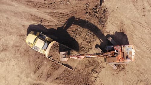 Excavator Loads Dirt into Dump Truck, Aerial View