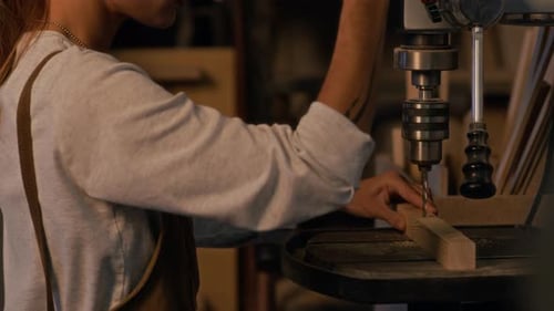 Woman Making Hole In Board With Drill