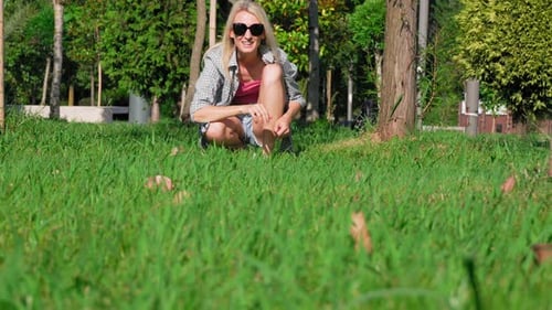 Girl plays with her toy terrier dog in park, she throws ball and dog runs