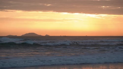 Sunrise on the Sea Coast Among Sea Waves and Clouds