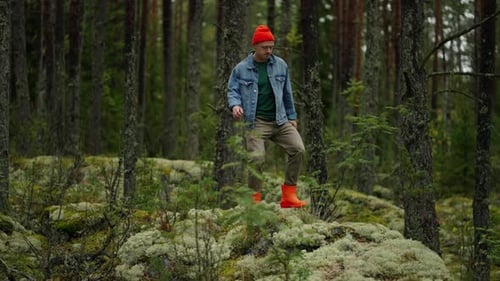 Man Hiking Through Mossy Forest