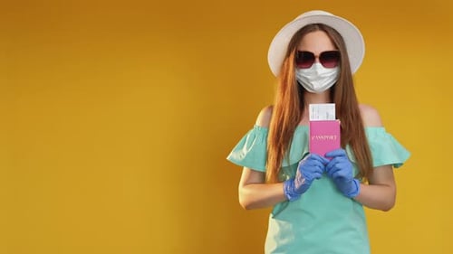 Woman Wearing Mask Holds Passport and Ticket